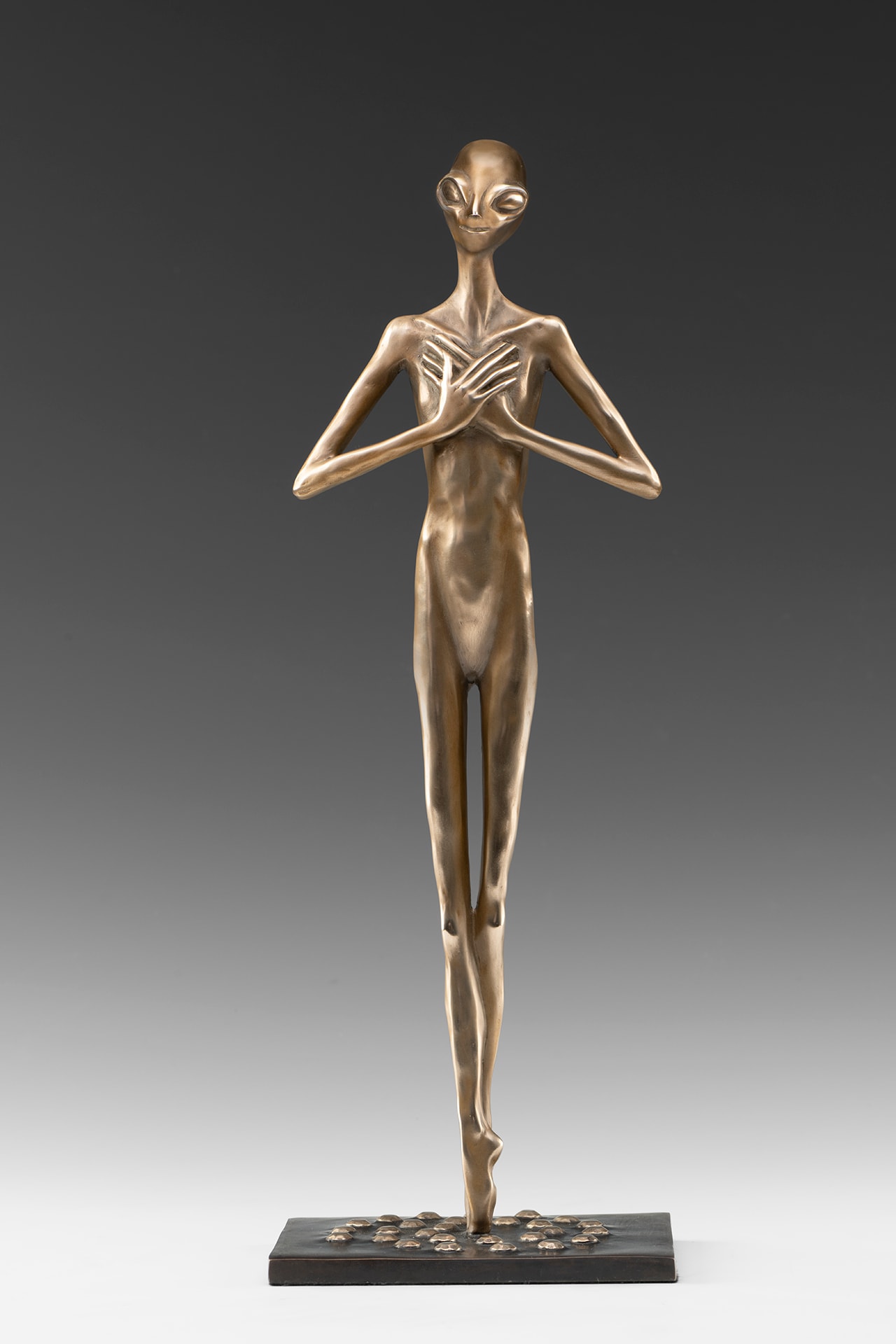 Tall thin bronze sculpture with almond-shaped eyes